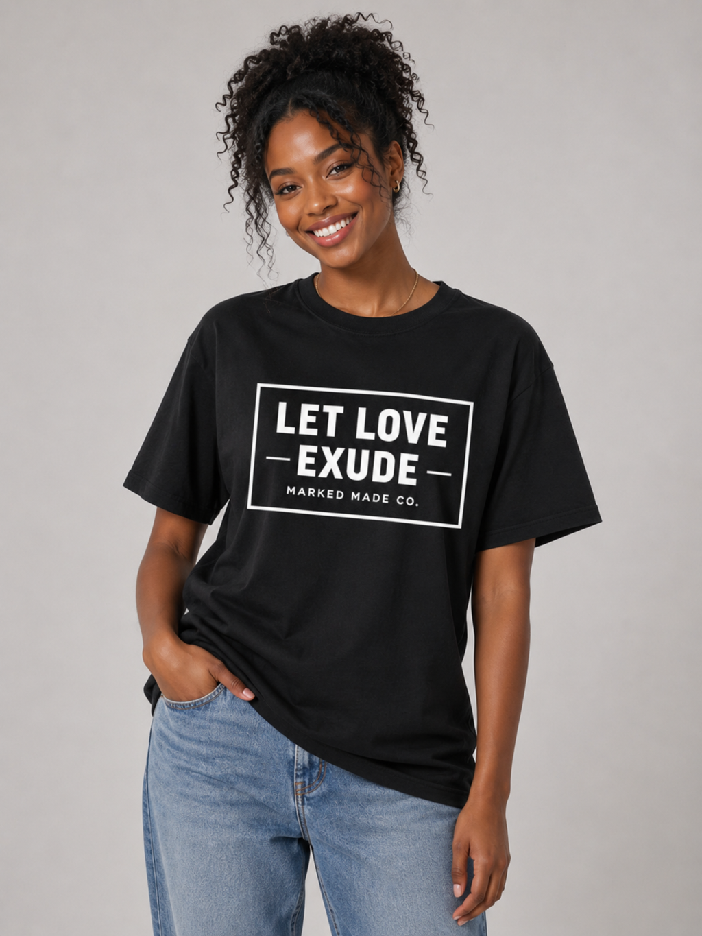 Person wearing a black t-shirt with 'LET LOVE EXUDE' text on a plain background