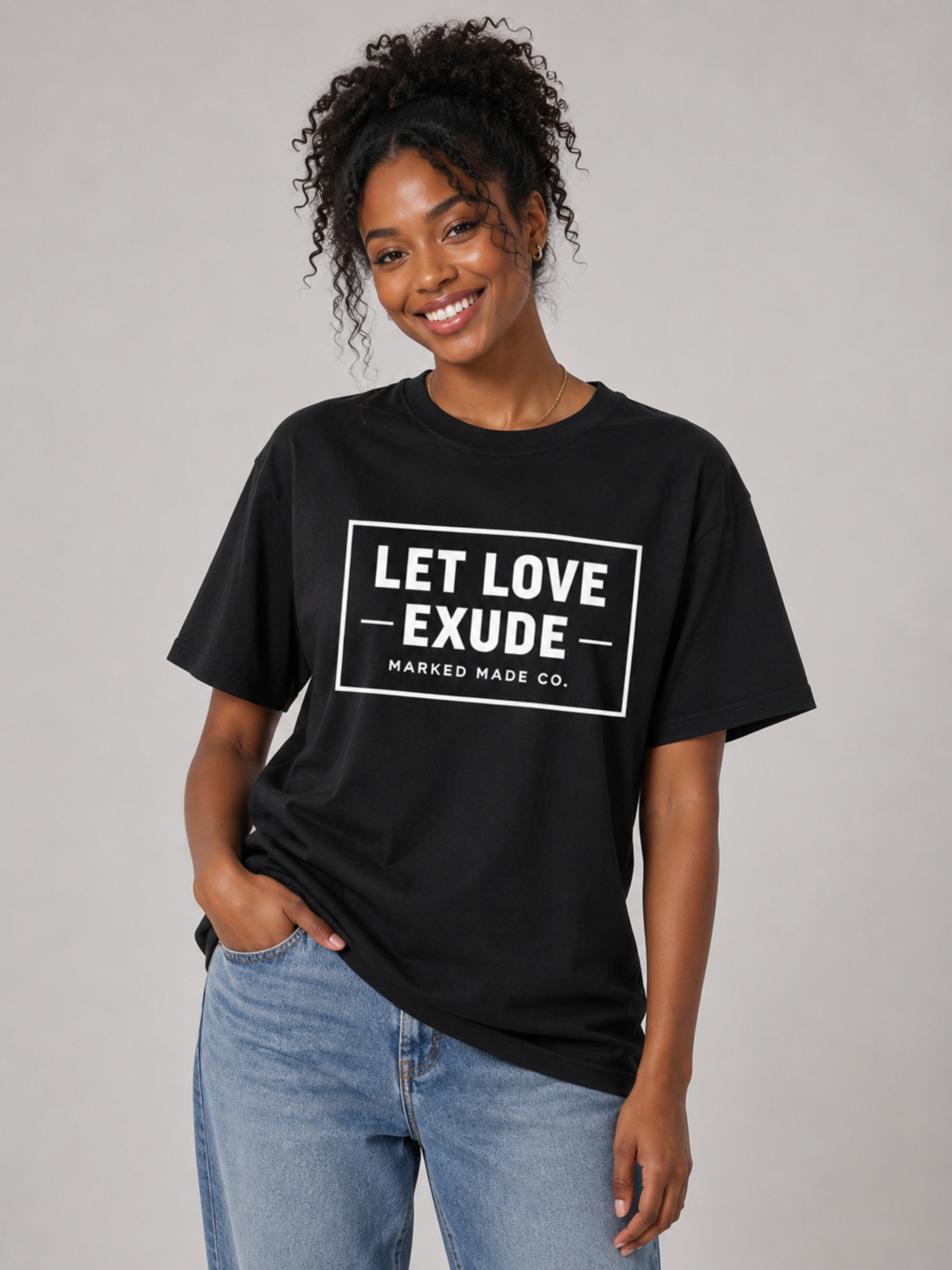 Person wearing a black t-shirt with 'LET LOVE EXUDE' text on a plain background
